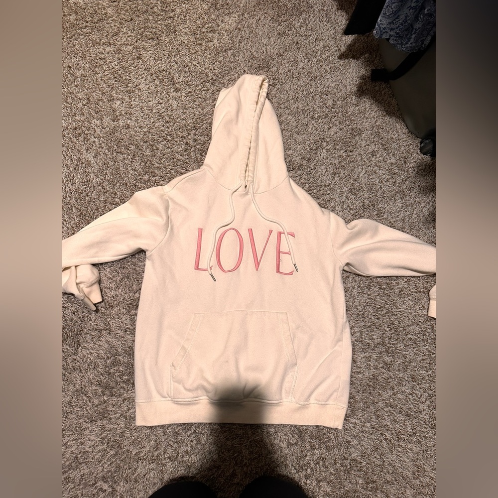 Cream hoodie with LOVE written on it with pink.
